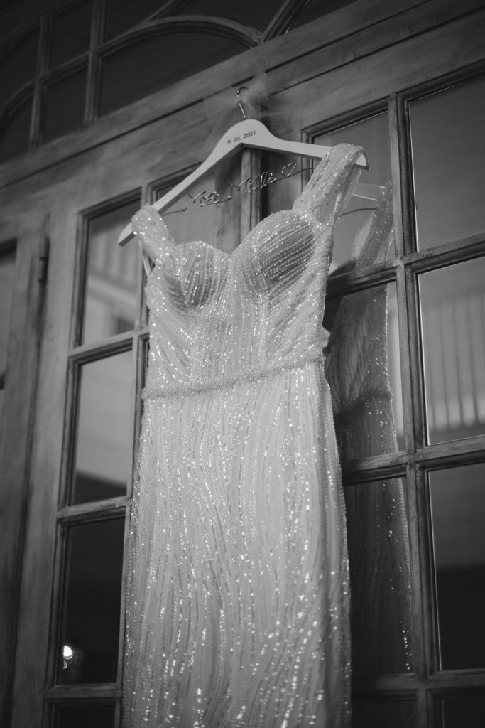 Sparkly wedding dress hanging on vintage door at Providence Vineyard Wedding Venue