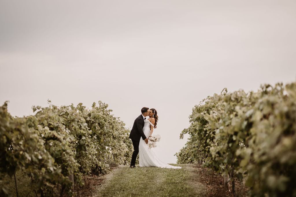 bride and groom kissing in vineyard at Providence Vineyard wedding venue