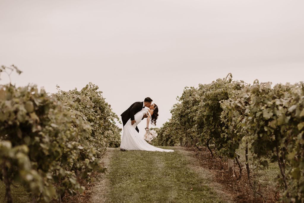 Bride and groom in vineyard kissing at Providence Vineyard wedding venue