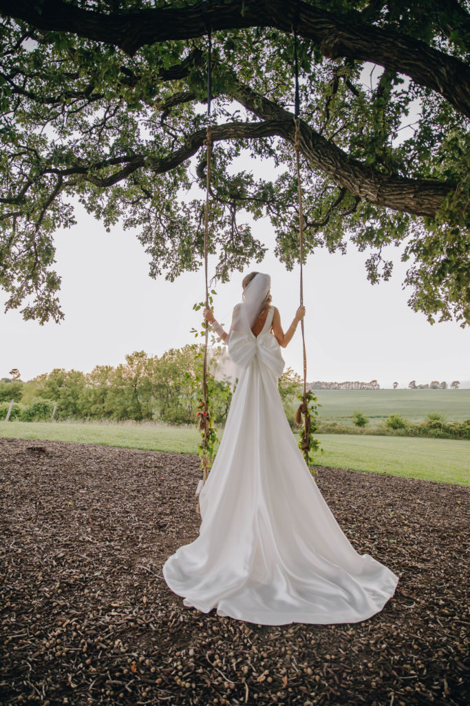 bride standing on swing at oak tree at Providence Vineyard WEdding Venue
