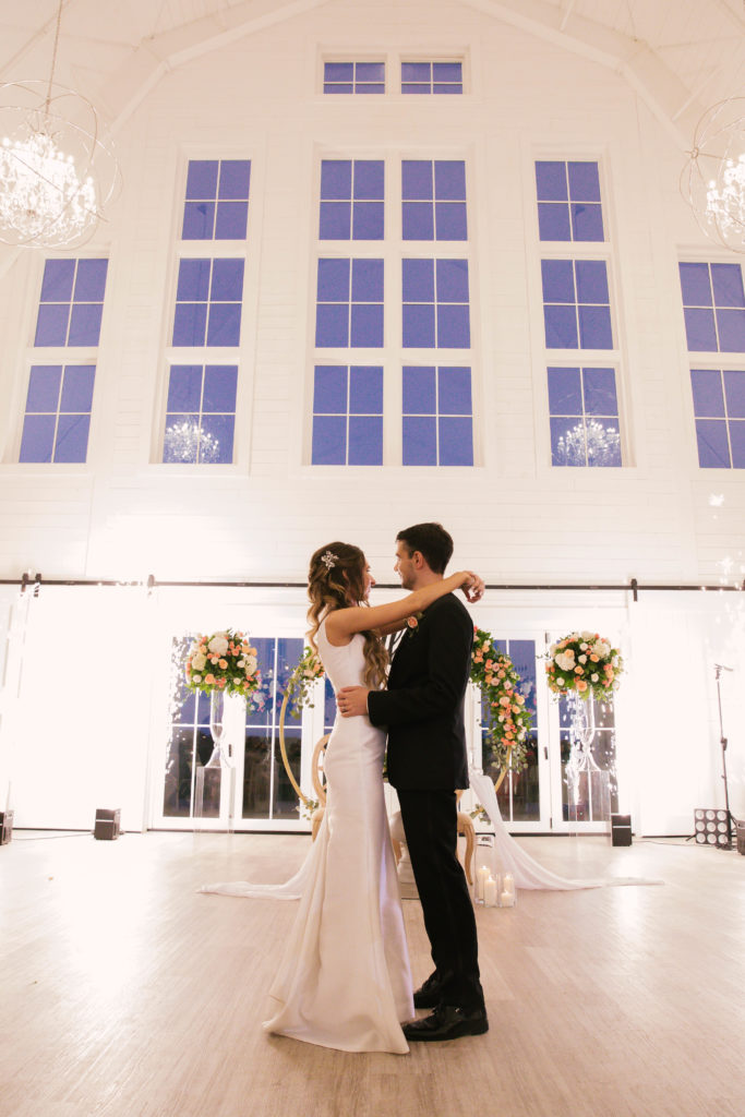 Bride and groom in white barn with window backdrop at Providence Vineyard Wedding Venue