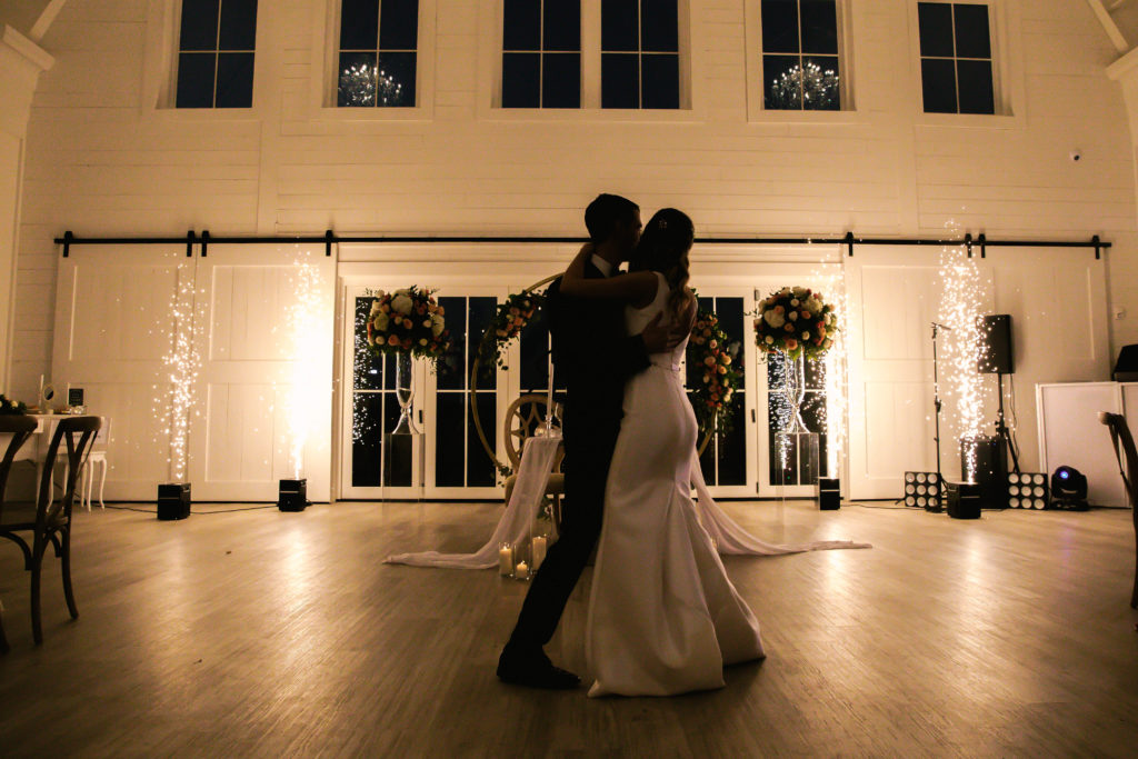 Bride and groom first dance with white lights white barn at wedding at Providence Vineyard Wedding Venue