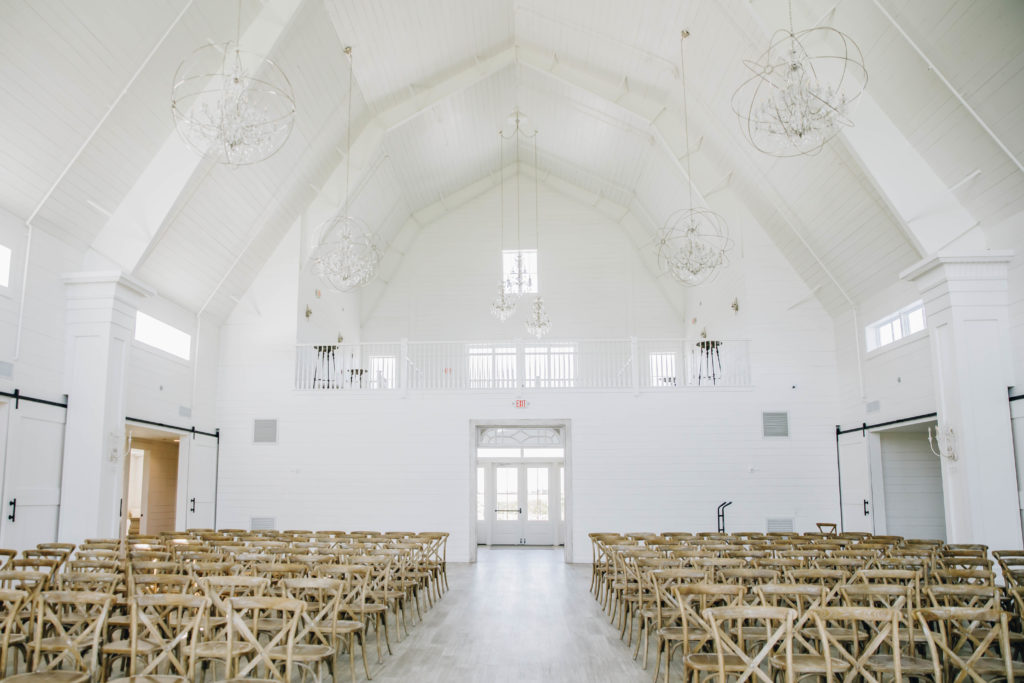 Indoor ceremony crossback chairs in white barn at PRovidence vineyard wedding venue